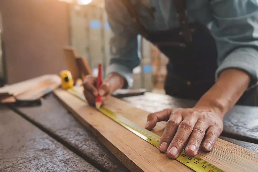 Carpenter-Insurance-Carpenter-Working-With-Equipment-on-Wooden-Table-in-Workshop