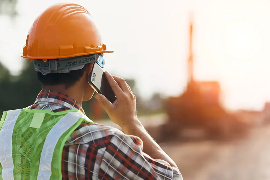 Client Center - Construction Worker Using a Phone on a Building Jobsite